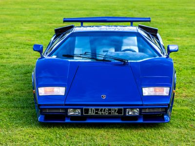 A Blue Lamborghini Countach Sits On Green Grass