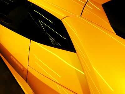A Close Up Of The Hood Of A Yellow Sports Car