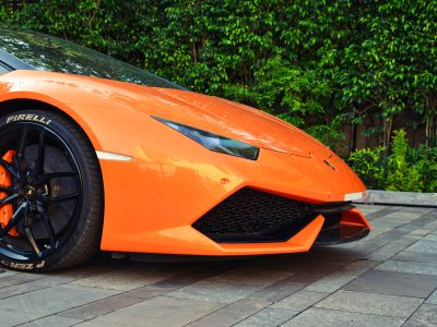 Orange Ferrari Car Parked Near Green Leaf Plants During