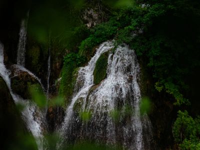 A Couple Of People Standing In Front Of A Waterfall