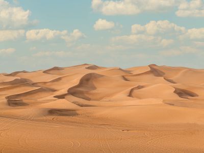 A Large Group Of Sand Dunes Under A Blue Sky