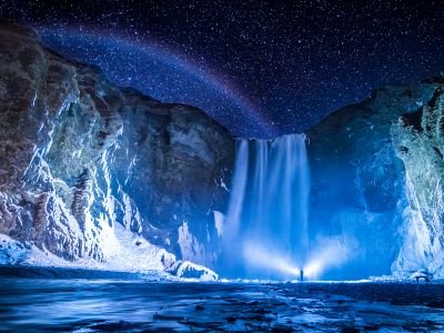 Person In Front Of Waterfalls During Nighttime