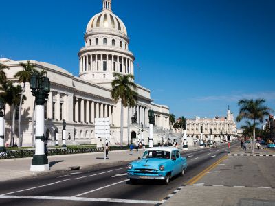 Blue Car On Road Near White Concrete Building During Daytime
