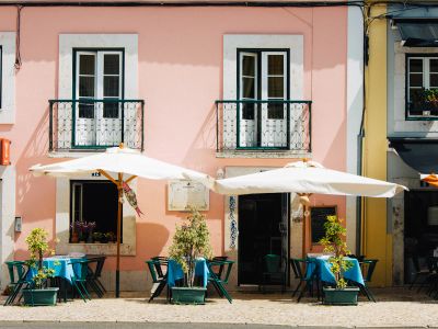 Two White Patio Umbrellas Near Pink And White Painted