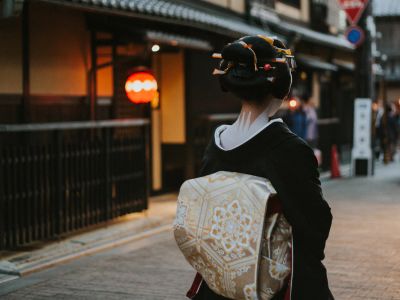 Woman In Black And White Floral Kimono Walking On Sidewalk